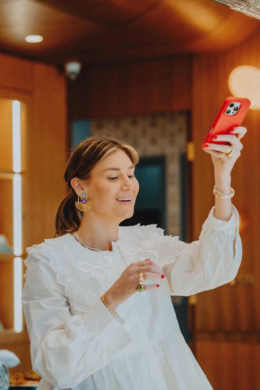 The host of a Wolfmoon catered event laughing as she takes a photo of her own gathering