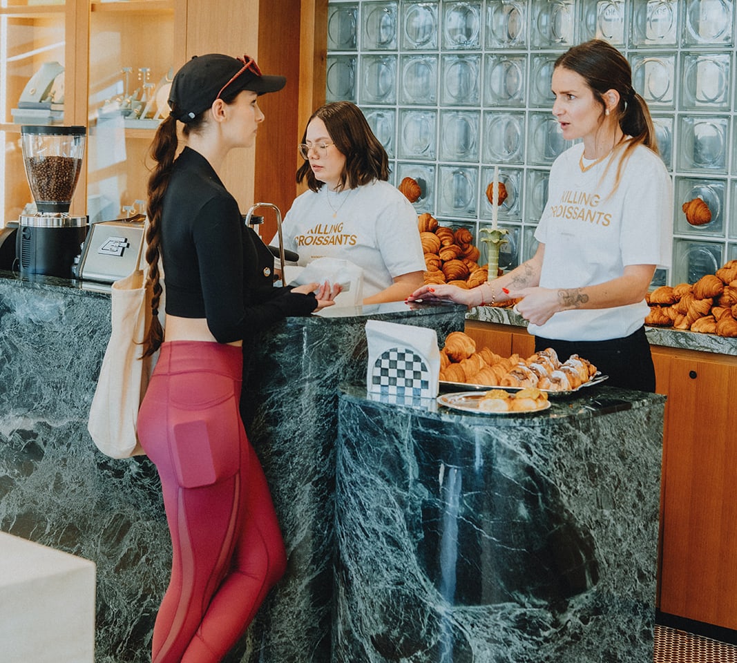 The Wolfmoon team serving a guest from a marble counter covered in croissants